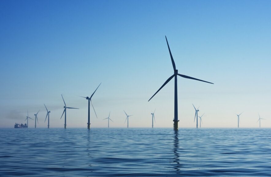 Offshore wind farm with turbines rising from a calm sea